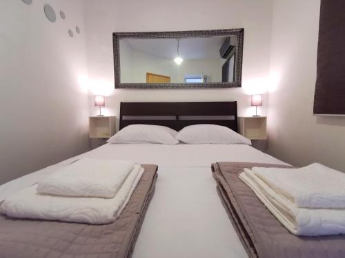 a bedroom with a large white bed with a mirror at Apartment Tatiana in Dubrovnik