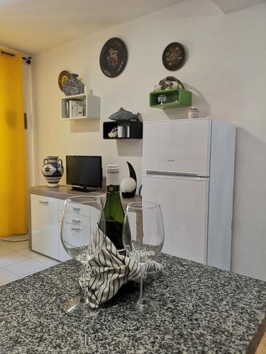 a kitchen with two wine glasses and a refrigerator at Maspalomas Casa La Loba in Maspalomas