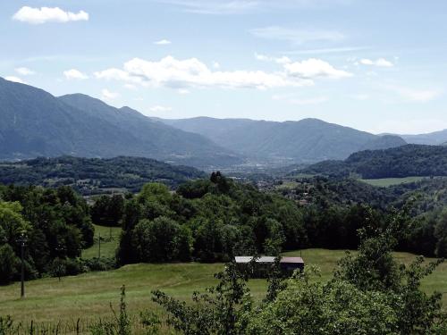 a view of a green field with mountains in the background at La casetta di Elsa in Cesiomaggiore