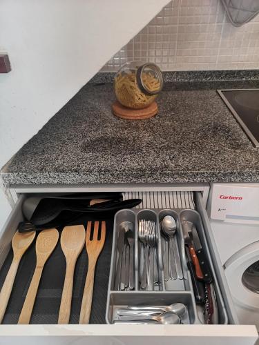 a kitchen counter with utensils in a drawer at Maspalomas Casa La Loba in Maspalomas