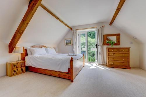 1 dormitorio con cama y ventana grande en Bramley Cottage, en Ottery St Mary