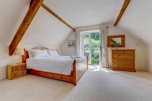 a bedroom with a bed and a large window at Bramley Cottage in Ottery Saint Mary