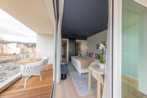 a bedroom with a bed and a desk and a balcony at Hotel Indigo Cagnes-sur-Mer by IHG in Cagnes-sur-Mer