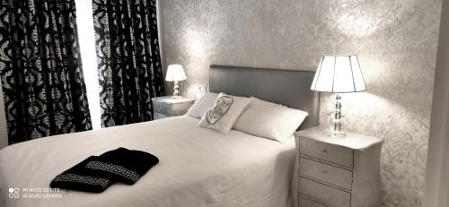 DUPLEX FUENGIROLA CENTRO 3 dormitorios في فوينخيرولا: غرفة نوم بسرير ابيض كبير ومصباحين