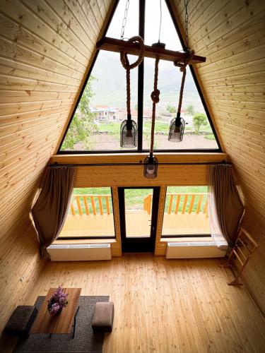 a room with a large window and a table at Pine Chalet Kazbegi in Stepantsminda