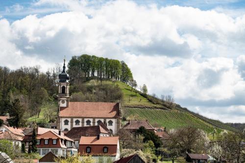 a village with a church and a hill with trees at Gasthaus zum Schwan in Castell