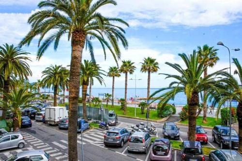 a parking lot with palm trees and the ocean at Quadrilocale da JO e ANTONIO in Loano