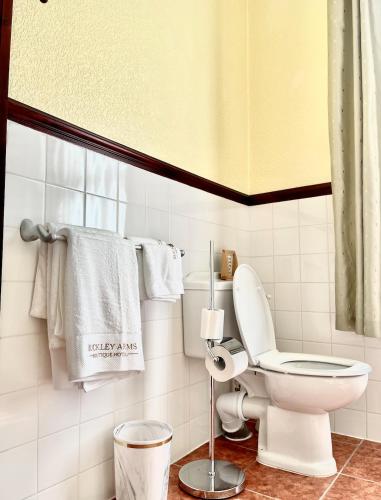 a bathroom with a toilet and towels on the wall at The Buckley Arms in Dinas Mawddwy