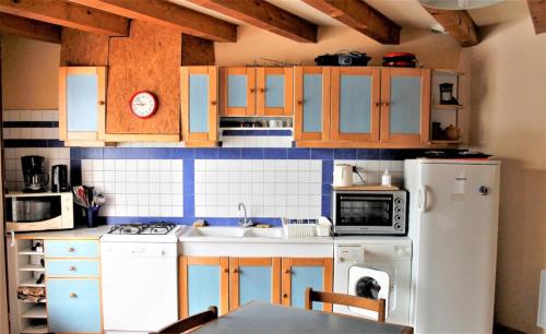 eine Küche mit Holzschränken und einem weißen Kühlschrank in der Unterkunft Maison de 3 chambres avec jardin amenage et wifi a Vaucluse 