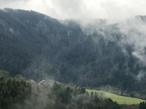 a misty mountain with houses and trees in the foreground at Maison chaleureuse à Vaucluse avec jardin spacieux 84 m² in Vaucluse