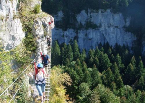 a woman on a suspension bridge in the mountains at Maison chaleureuse à Vaucluse avec jardin spacieux 84 m² in Vaucluse