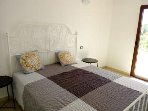 a bedroom with a large bed with two pillows at Il Poggetto Marzamemi - Le Villette in Marzamemi