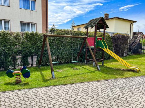 a playground with a slide in a yard at Villa Nadmorska Łeba Centrum in Łeba