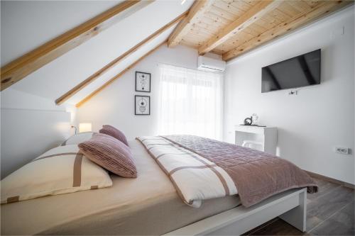 a bedroom with a bed in a white room at Villa Nesa - beautiful guest house at continental Croatia with Outdoor swimming pool, Sauna and 3 Bedrooms in Plaški