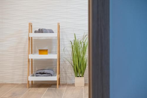 a towel rack with towels and a plant in a room at Villa Nesa - beautiful guest house at continental Croatia with Outdoor swimming pool, Sauna and 3 Bedrooms in Plaški