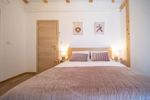 a bedroom with a large bed with two purple pillows at Villa Nesa - beautiful guest house at continental Croatia with Outdoor swimming pool, Sauna and 3 Bedrooms in Plaški