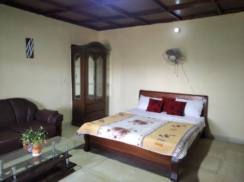 um quarto com uma cama e um sofá em Zion INN em Kigali