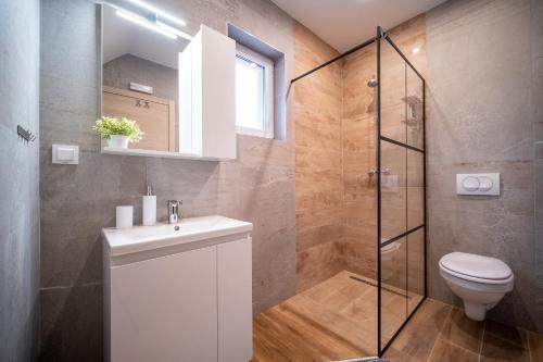 a bathroom with a shower and a toilet and a sink at Villa Nesa - beautiful guest house at continental Croatia with Outdoor swimming pool, Sauna and 3 Bedrooms in Plaški