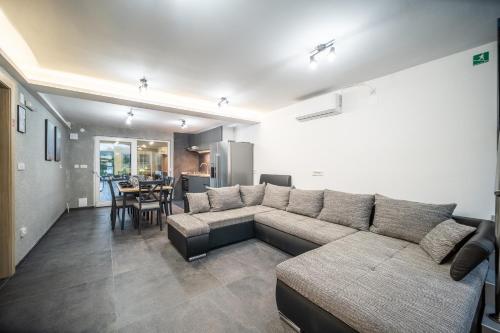 a living room with a couch and a dining room at Villa Nesa - beautiful guest house at continental Croatia with Outdoor swimming pool, Sauna and 3 Bedrooms in Plaški