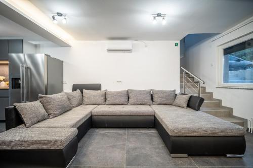 a large couch in a living room with a refrigerator at Villa Nesa - beautiful guest house at continental Croatia with Outdoor swimming pool, Sauna and 3 Bedrooms in Plaški