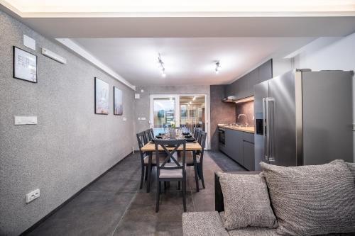 a kitchen and dining room with a table and a refrigerator at Villa Nesa - beautiful guest house at continental Croatia with Outdoor swimming pool, Sauna and 3 Bedrooms in Plaški