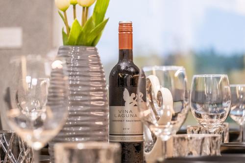 a bottle of wine sitting on a table with glasses at Villa Nesa - beautiful guest house at continental Croatia with Outdoor swimming pool, Sauna and 3 Bedrooms in Plaški