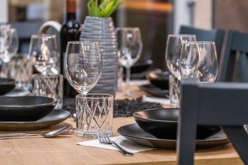 a table with wine glasses and plates on it at Villa Nesa - beautiful guest house at continental Croatia with Outdoor swimming pool, Sauna and 3 Bedrooms in Plaški