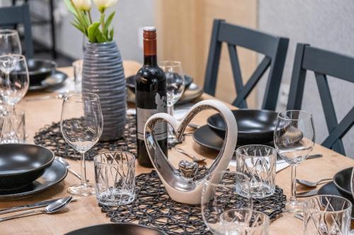 a table with a bottle of wine and glasses on it at Villa Nesa - beautiful guest house at continental Croatia with Outdoor swimming pool, Sauna and 3 Bedrooms in Plaški