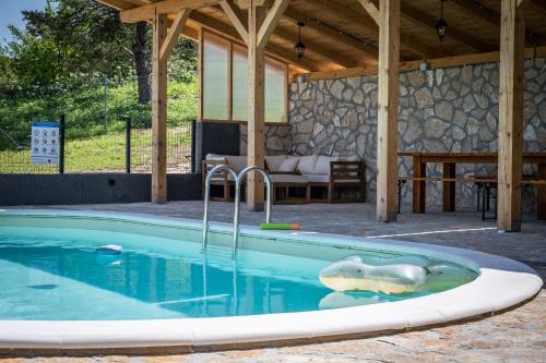 a swimming pool with a shark toy in the water at Villa Nesa - beautiful guest house at continental Croatia with Outdoor swimming pool, Sauna and 3 Bedrooms in Plaški