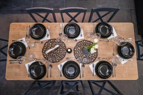 a wooden table with black plates and glasses on it at Villa Nesa - beautiful guest house at continental Croatia with Outdoor swimming pool, Sauna and 3 Bedrooms in Plaški
