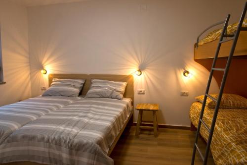Apartmaji Tanto Malovše في Črniče: غرفة نوم بسريرين وسرير بطابقين