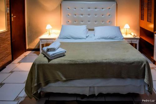 a bedroom with a large bed with two night stands at Pousada Valle dos Pássaros in Penedo