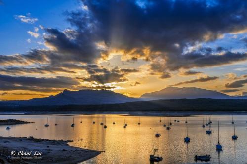 a sunset over a body of water with boats at El Lago in Cervera de Buitrago