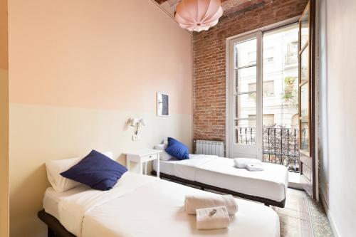 two beds in a room with a window at Moianes Apartment by Olala Homes in Barcelona