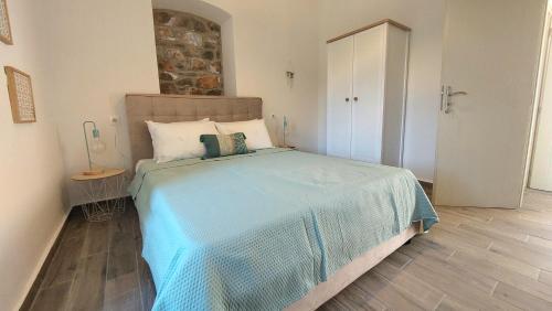 Schlafzimmer mit einem Bett mit blauer Decke in der Unterkunft Melita Traditional Stone House in Pyrgos Dirou
