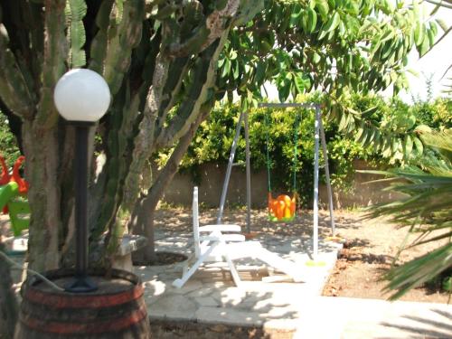 a park with a swing and a tree at Villa Rosa in Modica