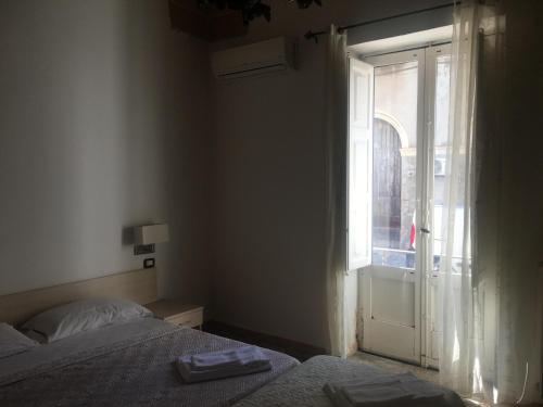 a bedroom with a bed and an open window at Stelmalu' in Novoli