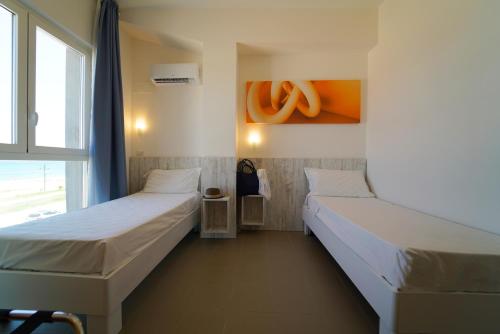 a room with two beds and a window at Hotel Rivabella in Davoli