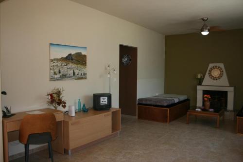 een kamer met een slaapkamer met een bed en een bureau bij KIKI Stegna in Archangelos
