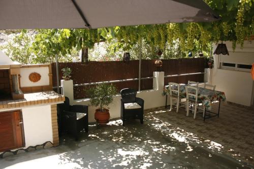 a patio with a table and chairs and an umbrella at KIKI Stegna in Archangelos