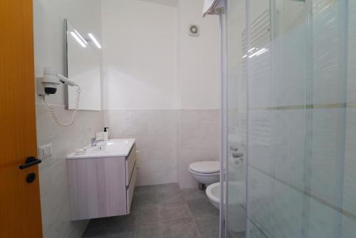 a bathroom with a toilet and a glass shower at Hotel Rivabella in Davoli
