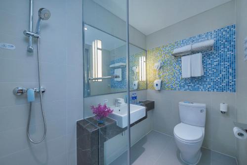 a bathroom with a toilet and a sink and a shower at Holiday Inn Express Zhengzhou Longzi Lake by IHG in Yaoqiao