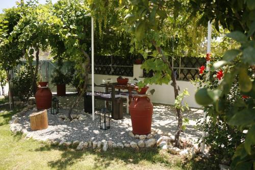 a garden with two large vases and a table at KIKI Stegna in Archangelos