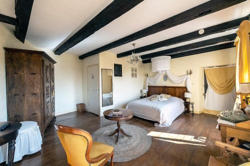 a bedroom with a bed and a table and chairs at Le Clos d'Albray - Chambres d'hôtes et gite in Comps-la-Grand-Ville