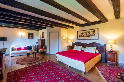 a bedroom with a large bed and a couch at Le Clos d'Albray - Chambres d'hôtes et gite in Comps-la-Grand-Ville