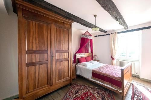 a small bedroom with a bed and a wooden closet at Le Clos d'Albray - Chambres d'hôtes et gite in Comps-la-Grand-Ville