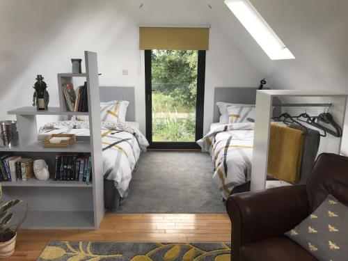 a bedroom with two beds and a window at The Cartlodge in Hollesley