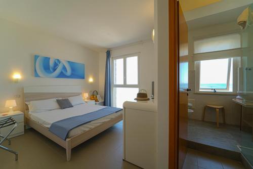 a bedroom with a bed and a room with a bathroom at Hotel Rivabella in Davoli