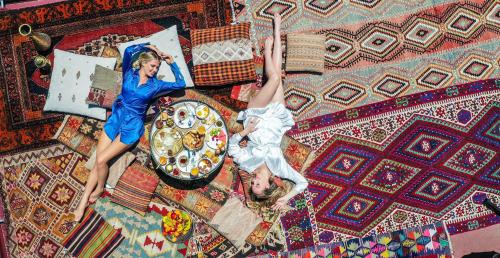 two women are laying on a rug at Mak's Cave House in Uchisar