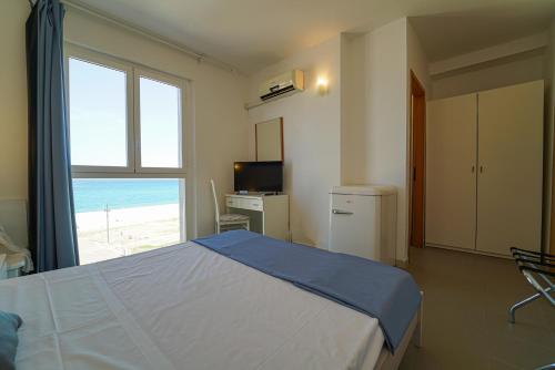 a bedroom with a bed and a view of the beach at Hotel Rivabella in Davoli